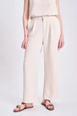 Pantalón de vestir color crudo, de corte palazzo y tiro alto.