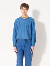 Top de manga larga color azul, confeccionado en denim paper touch. Presenta cuello redondo y recortes en el frente que estilizan la silueta. Tiene cartera en la espalda con broches para facilitar el acceso.