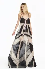 Vestido largo de chiffon negro con tirantes finos, diseño fluido y detalles de encaje en tono beige. Presenta un lazo frontal en color rosado y una silueta elegante con caída ligera.