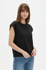 Remera negra de algodón, holgada, de cuello redondo y mangas cortas con dobladillo vuelto.