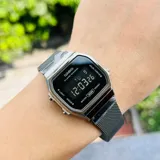 Reloj digital Casio estilo vintage con caja de 33mm y esfera negra. Cuenta con brazalete de acero inoxidable en color negro con malla milanesa, funciones de cronómetro, alarma y calendario automático.