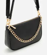 Cartera tipo shoulder baguette de tamaño pequeño, confeccionada en poliuretano con textura símil reptil. Presenta un diseño estructurado con cierre superior, correa larga ajustable y removible, y una cadena metálica decorativa en la parte frontal.