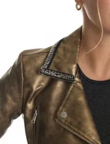 Chaqueta tipo biker de eco cuero con acabado metalizado dorado. Presenta cuello con solapa decorado con ribete bordado de pedrería y strass, cierre frontal asimétrico con cremallera metálica y bolsillos laterales funcionales con cierre.