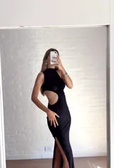 Vestido negro de fiesta, largo midi, con un solo hombro y abertura en la cintura.