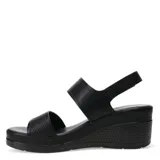 Sandalias de plataforma con diseño de tiras en cuero sintético color tostado. La tira delantera presenta una textura grabada, mientras que la tira trasera incluye un cierre con hebilla y detalle metálico. Posee una base de plataforma blanca con diseño estriado.