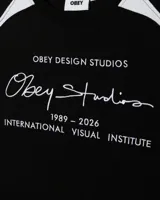 Remera de manga larga Obey, color blanco con paneles laterales y en hombros en color azul. Presenta estampado gráfico frontal con tipografía y logo de la marca.