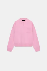 Sweater tipo polo de punto liso, con cuello solapa, manga larga y bolsillo delantero de plastrón. Presenta cierre frontal con botones y puños y ruedo acanalados.