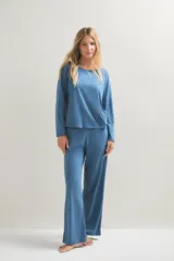 Pijama de dos piezas compuesto por una remera de manga larga con cuello redondo y un pantalón de corte recto y holgado. Ambas prendas presentan un estampado de pequeños puntos oscuros sobre una base de color azul.