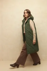 Chaleco largo marrón capitoneado con capucha, cierre frontal y bolsillos laterales. Forro interno de satén con estampado animal print.