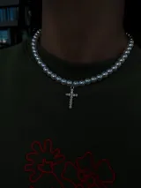 Collar de perlas blancas con dije de cruz plateada con incrustaciones de strass.