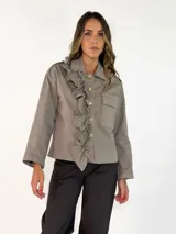 Chaqueta negra de algodón con diseño de volados en el frente, cierre de botones y bolsillos laterales.