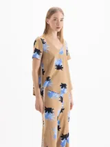 Remera marrón melange con estampa floral en tonos azules y negros, cuello en V y mangas cortas.