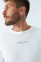 Remera básica de hombre color blanco, de manga larga y escote redondo, con logo y arte estampado en el pecho que dice "NEVER STOP EXPLORING Established in Torino, Italy. Since 1971".
