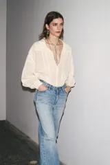 Jeans de tiro alto con corte recto y efecto lavado. Cuenta con cinco bolsillos, trabillas en la cintura y cierre frontal con cremallera y botón.