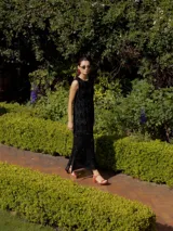 Vestido midi de punto sin mangas, con diseño de rombos en la parte superior y textura de red en la parte inferior. Confeccionado con hilo con lurex que aporta un brillo sutil, presenta un corte recto y tajos laterales en el ruedo.