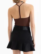 Top gris de punto, ajustado al cuerpo, con escote en V pronunciado y breteles finos que se unen en la espalda.