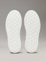 Zapatillas urbanas Calvin Klein de cuero blanco con logo CK en el lateral y detalle de gamuza color salmón en el talón.