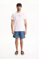 Remera blanca de algodón, de corte regular y manga corta, con estampa frontal centrada con texto en tonos oscuros.