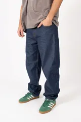 Pantalón de jean azul oscuro con corte baggy y calce relajado. Presenta cinco bolsillos clásicos y costuras reforzadas en tono contrastante.