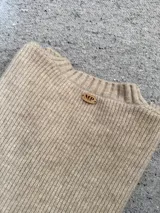 Sweater color beige de hilo de viscosa, con cuello redondo y mangas largas.