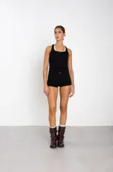 Botas de caña media confeccionadas en cuero color marrón oscuro, con diseño arrugado y dos correas con hebillas metálicas ajustables. Presentan suela plana de goma negra con un pequeño taco cuadrado.