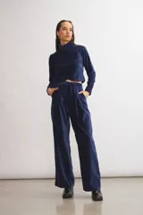 Top de terciopelo azul marino, de corte cropped, con cuello alto y espalda descubierta.