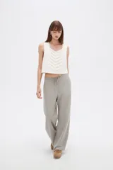 Pantalón de algodón color gris, de tiro medio y corte holgado tipo baggy, con bolsillos laterales y cordón ajustable en la cintura.