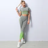 Conjunto deportivo gris con detalles en verde neón, compuesto por una remera corta de mangas cortas y calzas largas con cintura alta.