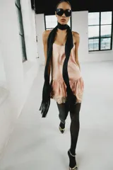 Vestido corto de estilo lencero, color rosado, con escote redondo, tirantes finos ajustables, bajo acabado en volante y detalles de encaje combinado a tono.