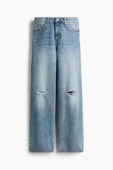 Jean de tiro alto confeccionado en denim de algodón lavado con diseño de cinco bolsillos, piernas rectas y holgadas, y detalles de roturas en las rodillas.