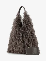 Cartera de diseño amplio y estructura flexible, confeccionada en textura de pelo sintético que aporta volumen. Cuenta con asas cortas integradas para llevar al hombro o en la mano.