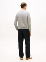 Sweater gris de punto texturizado, de cuello redondo, con detalles de ribetes en punto canalé en puños, cuello y bajo. Presenta un pequeño logo bordado en el pecho.