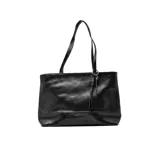 Cartera al hombro Korium modelo Leire, color negro, con diseño estructurado, doble asa larga, detalle de llavero con forma de llave y tira trenzada colgante.