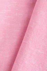 Camisa de corte oversized en tejido liviano de lino y viscosa, de color rosado. Cuenta con cuello clásico, cierre frontal de botones, hombros caídos y mangas largas con puños abotonados. El diseño se completa con un bajo redondeado.