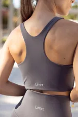 Top deportivo negro con breteles anchos y espalda deportiva.