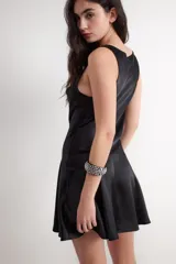 Vestido corto negro de acabado satinado tipo gloss, sin mangas, con escote drapeado y falda evasé con corte asimétrico.