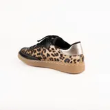 Zapatilla de estilo retro confeccionada en cuero vacuno, con diseño combinado en cuero negro y estampado animal print. Presenta detalles en cuero metalizado dorado en el talón, cordones negros y suela de goma color caramelo con costura reforzada.