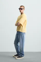 Camiseta gris de corte cuadrado y holgado, con cuello redondo y mangas cortas.