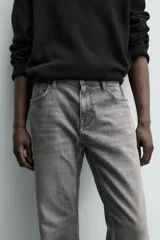 Pantalón de jean corte slim fit, color gris con efecto lavado. Presenta diseño de cinco bolsillos, cierre frontal con cremallera y botón, y tejido elástico.