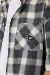 Camisa de manga corta de popelina cuadrillé en tonos marrón, blanco y gris, con diseño boxy fit, cuello camisero, cierre frontal de botones, bolsillo en el pecho con detalle bordado y dobladillo recto.