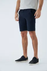 Bermuda tipo chino de corte clásico, confeccionada en una mezcla de lino y algodón. Presenta cierre de cremallera y botón, bolsillos laterales y traseros, y trabillas para cinturón.