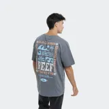 Remera de corte oversize color azul, con cuello redondo y manga corta. Presenta un pequeño estampado gráfico en el pecho con el logo de la marca Reef.