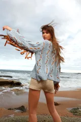 Sweater celeste de lana mohair con diseño de trenzas y apliques de cuero color suela.