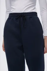 Pantalón tipo babucha de corte recto, confeccionado en tejido con felpa, con cintura elástica y cordón de ajuste frontal.