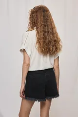 Short de jean blanco de tiro medio con silueta relajada y detalle de ruedo desflecado con flecos.