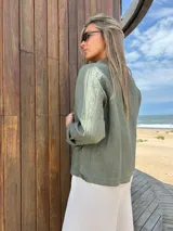 Blazer verde militar de lino con corte entallado, solapas clásicas, cierre con dos botones, bolsillos delanteros y mangas 3/4 con detalle de botón.