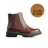 Bota tipo chelsea de cuero color bordó, con paneles laterales elásticos y suela track negra con costuras visibles en contraste.