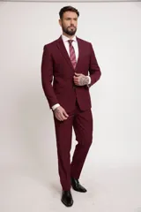 Traje de dos piezas color bordó, compuesto por saco de corte slim fit con solapa clásica, cierre de un botón y bolsillos laterales, y pantalón de vestir a juego de corte recto.