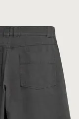 Pantalón wide fit color rojo terracota, con pliegues frontales, bolsillos laterales y cierre frontal con cremallera y botón.
