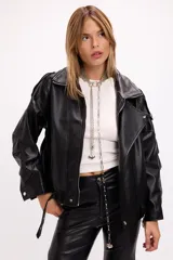 Campera estilo bomber oversize confeccionada en símil cuero negro con textura granulada. Presenta cuello alto con cierre frontal, hombreras marcadas, bolsillos laterales y cintura con elástico y cinto ajustable con hebilla metálica.